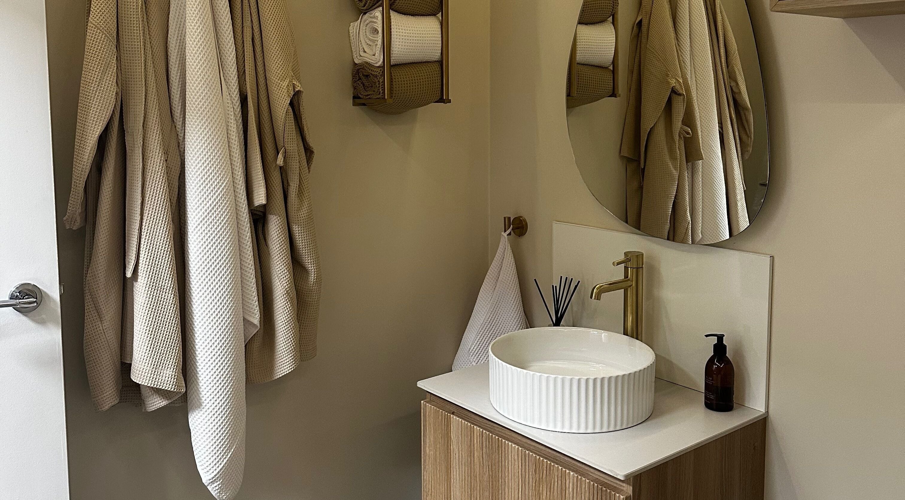 Luxurious bathroom at Rituals Holistic Massage, Cardiff, Wales, GB, featuring robes and a stylish vanity.