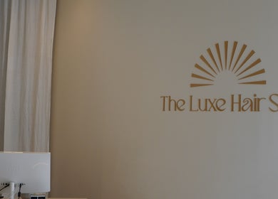 Reception area at The Luxe Hair Spa in Barcelona, Catalunya. Minimalist design with logo in gold.