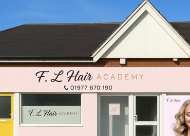 Exterior of Alex Jamieson Hairdressing in Knottingley, England, GB with stylish signage and bright facade.
