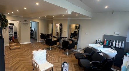 Elegant interior of Alex Jamieson Hairdressing in Knottingley, England, GB. Modern chairs, mirrors, and wash stations visible.