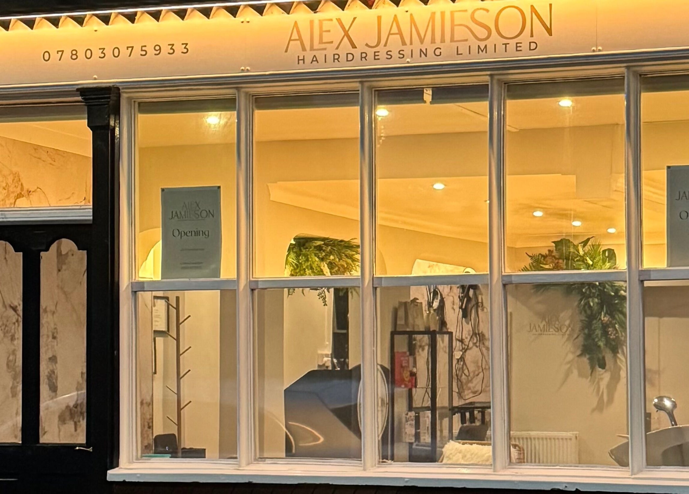 Front view of Alex Jamieson Hairdressing in Knottingley, England, GB featuring warmly lit interior.