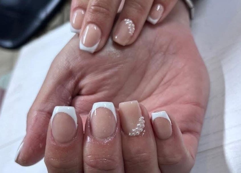 Elegant French manicure with pearls at Glamour Aesthetix in Boksburg, Gauteng, ZA, showcasing pristine nail art.