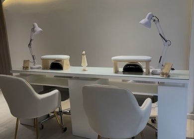 Área de manicura en CMBeauty, La Reina, Región Metropolitana, CL, con estaciones modernas blancas iluminadas.