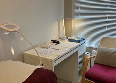 Cozy treatment room at Delight Laser Spa, New Barnet, England, GB, featuring a desk and comfortable chair.