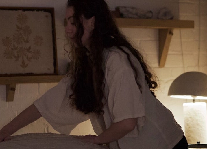 Therapist preparing a treatment room at Alchème Sanctuary, London, England, GB for a calming session.