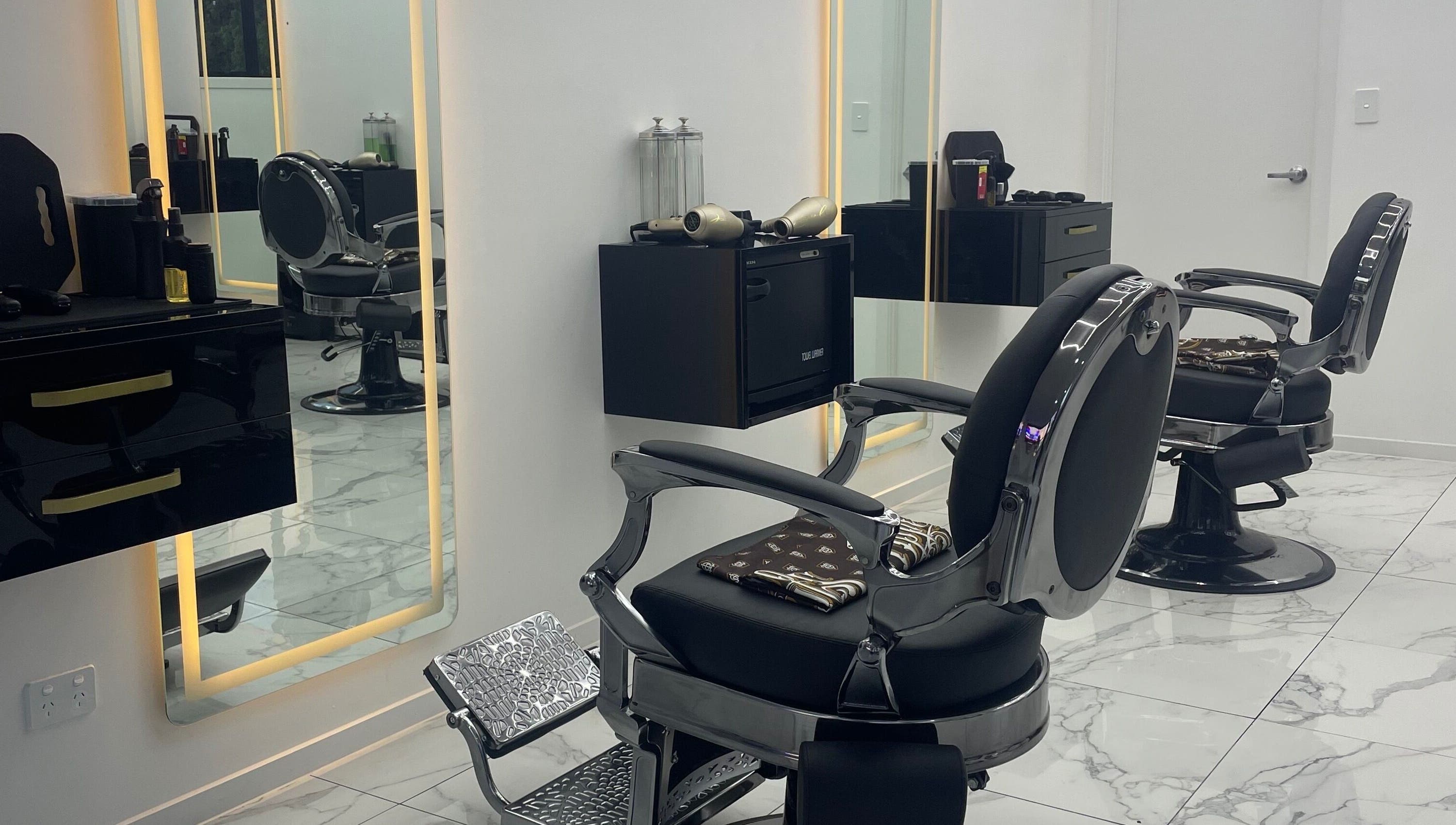 Elegant, modern barber chairs at Crwn Barbers in Auckland, Auckland, NZ with stylish decor and lighting.