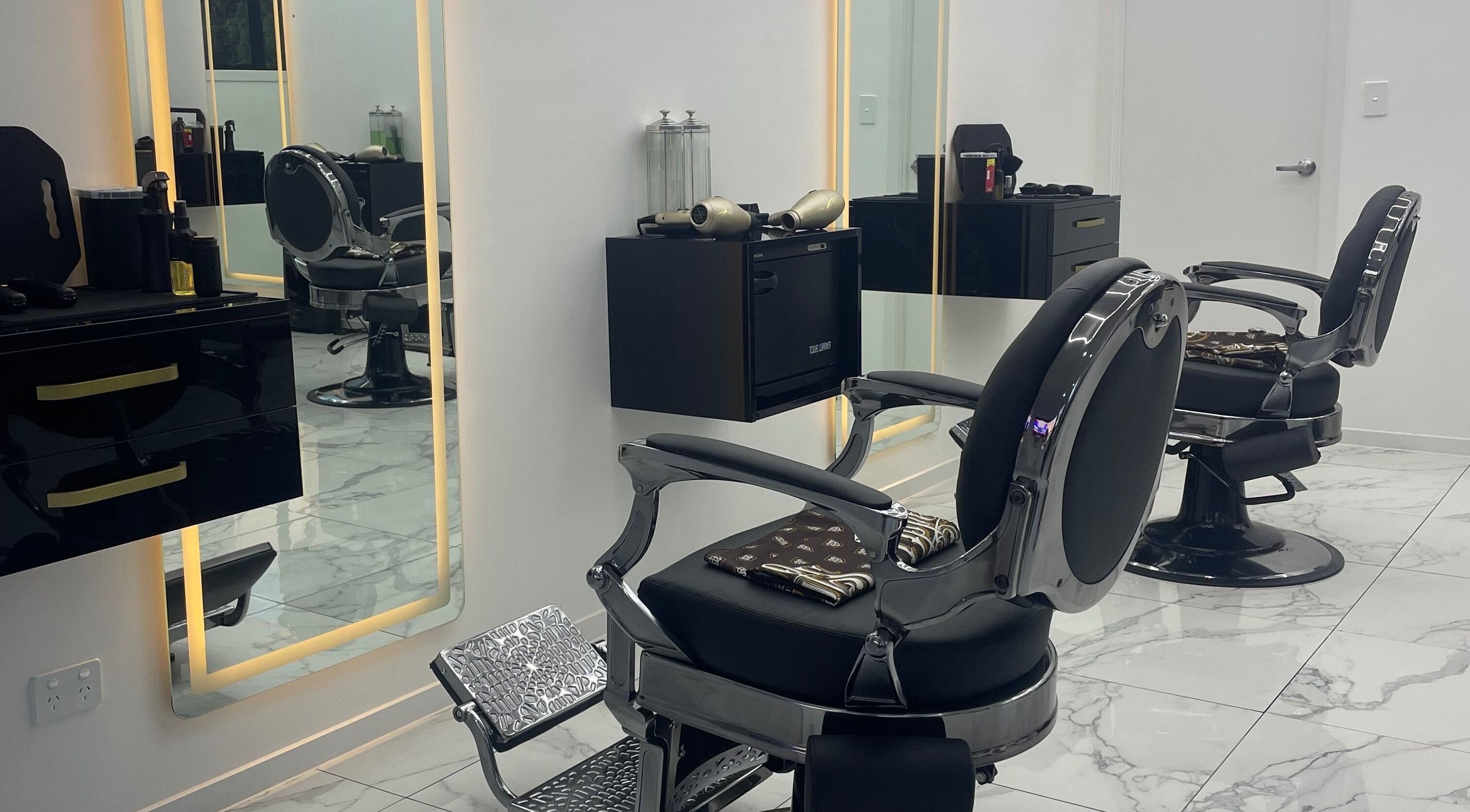 Elegant, modern barber chairs at Crwn Barbers in Auckland, Auckland, NZ with stylish decor and lighting.