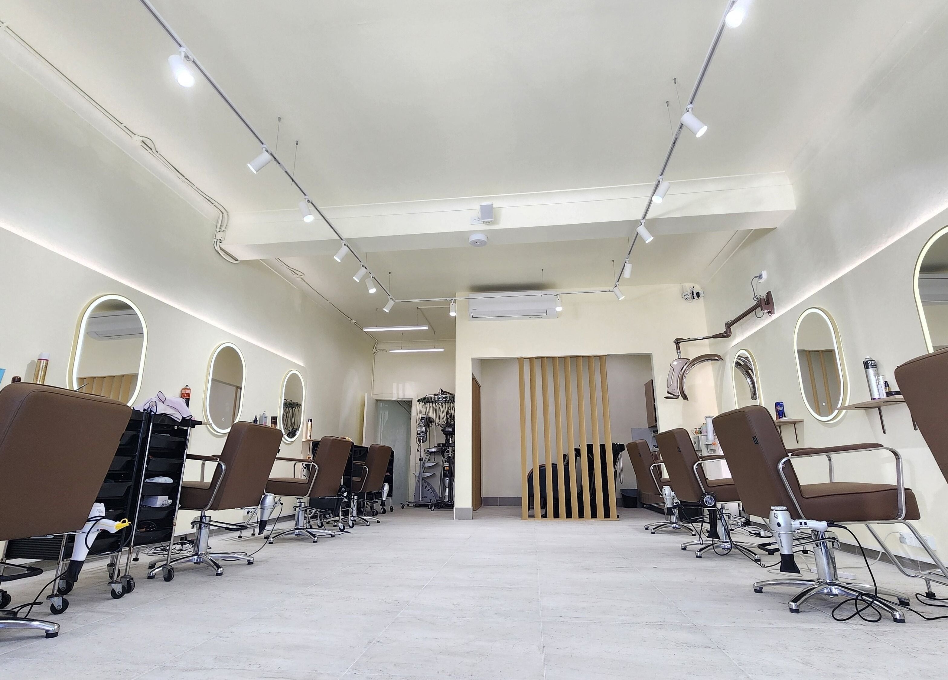 Modern salon interior at Perm Perm Hair, Lidcombe, New South Wales, AU with sleek styling chairs and mirrors.