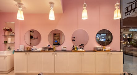 Bright salon interior of Exquisite Brows and Spa Liverpool, New South Wales, AU with elegant decor and round mirrors.