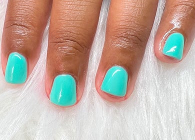 Turquoise manicure at Luxe Studio, Christ Church, BB on a plush white surface.