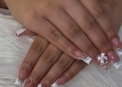 Chic nail art with gems and bow designed at Nailzbybrenisbel, Rockville, Maryland, US.