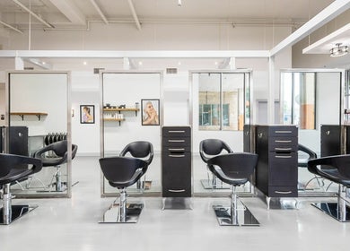 Modern salon setup at Mark Yared Hair Stylist in Austin, Texas, US featuring sleek black chairs and mirrors.