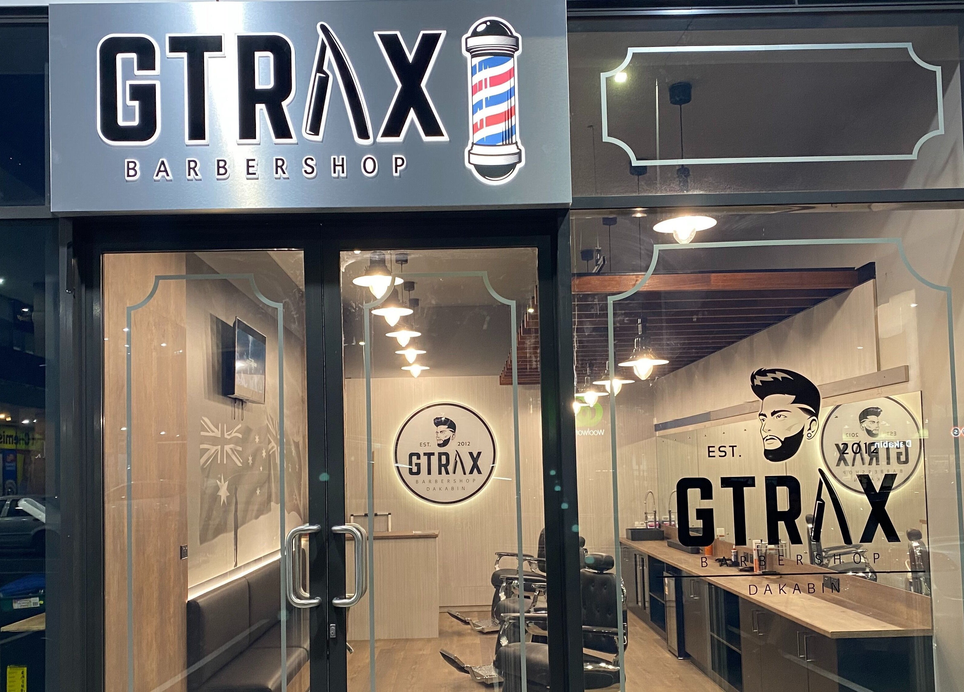 Front view of Gtrax Barbershop in Dakabin, Queensland, AU showcasing modern interior through glass doors.