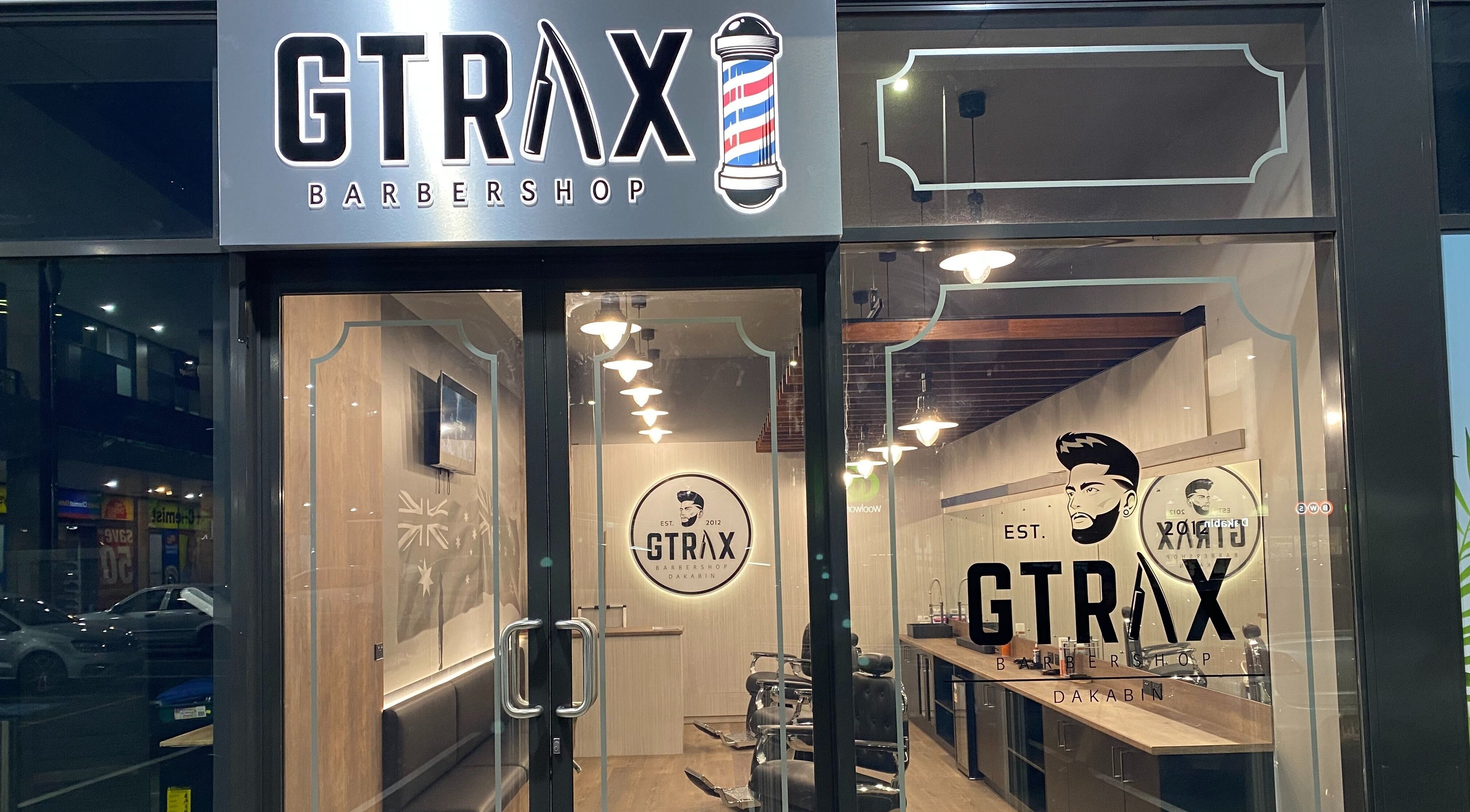 Front view of Gtrax Barbershop in Dakabin, Queensland, AU showcasing modern interior through glass doors.