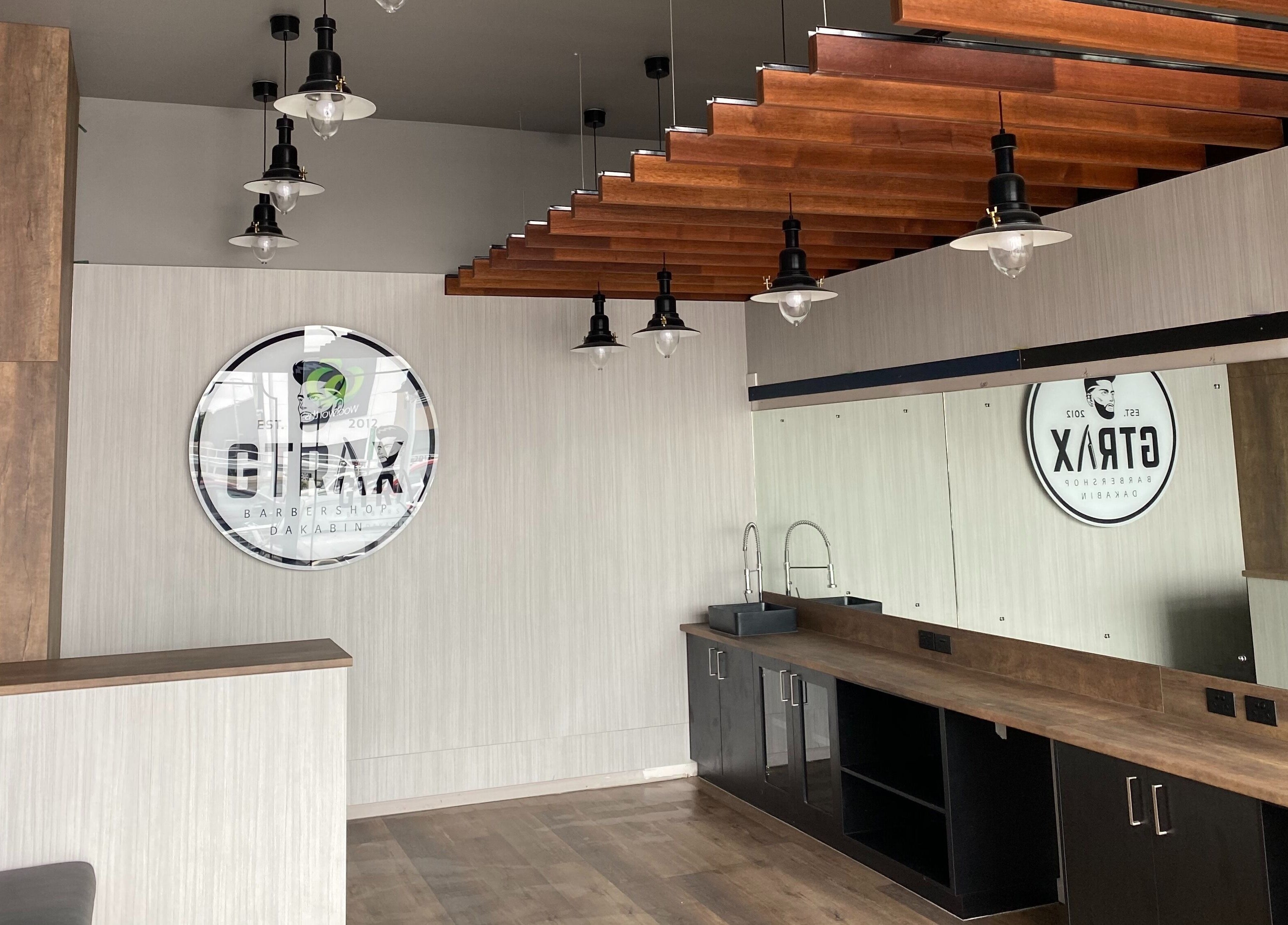 Modern interior of Gtrax Barbershop in Dakabin, Queensland, AU with wooden accents and sleek lighting.