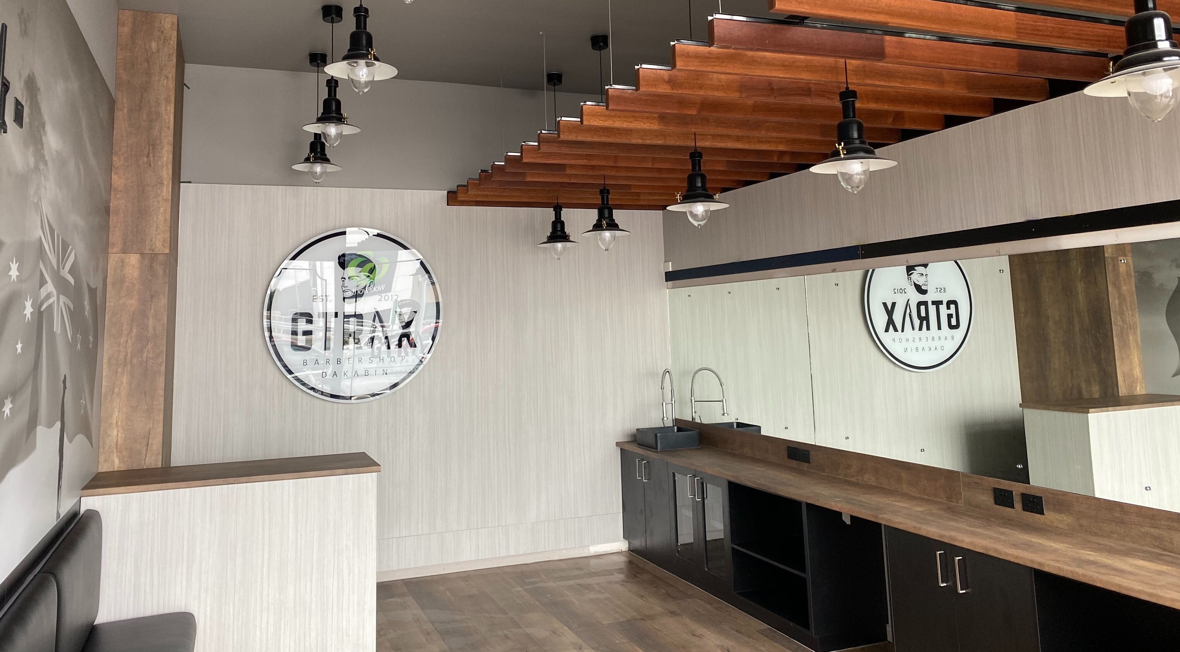 Modern interior of Gtrax Barbershop in Dakabin, Queensland, AU with wooden accents and sleek lighting.