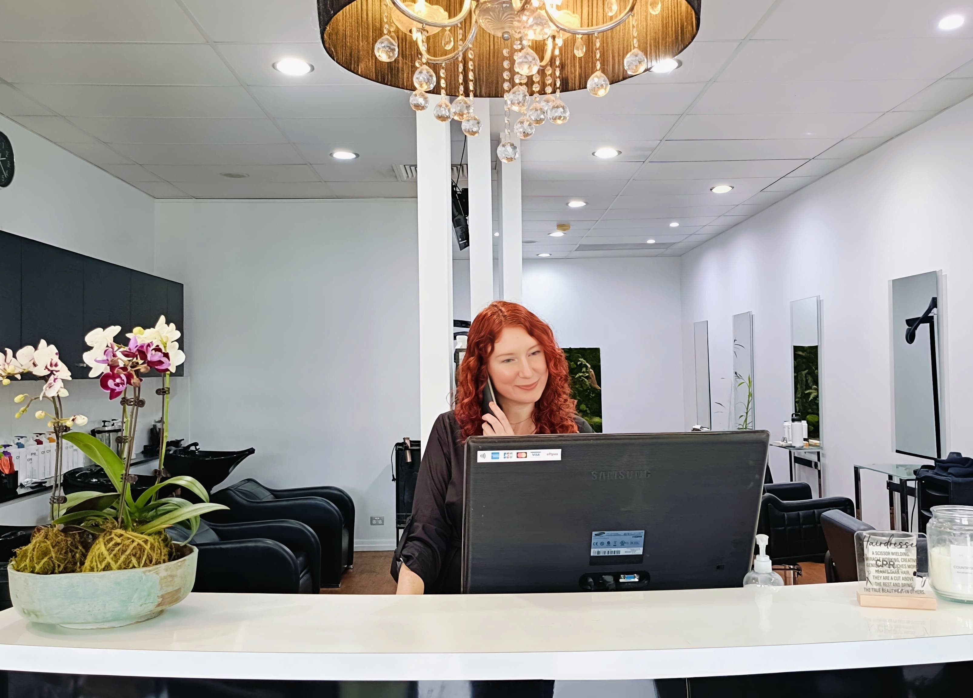 Reception area at Imaj For Hair, Gympie QLD with a welcoming staff member at the desk.