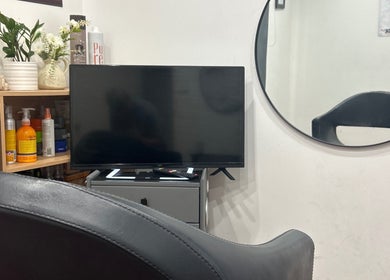 Mohit hairdresser seating area with TV and decor, Gosnells, Western Australia, AU.