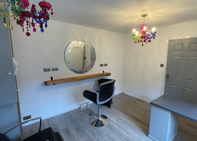 Stylish salon interior at Eagle House Salon, Southwell, England, GB, featuring colorful chandeliers and modern decor.