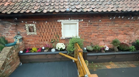 Charming garden exterior at Eagle House Salon, Southwell, England, GB, featuring vibrant flowers and rustic decor.