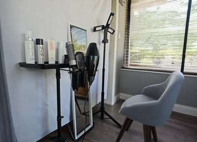 Modern styling area at Cuts by Luke, Croydon, England, GB, featuring hair products, brushes, and a chair.