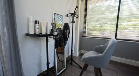 Modern styling area at Cuts by Luke, Croydon, England, GB, featuring hair products, brushes, and a chair.