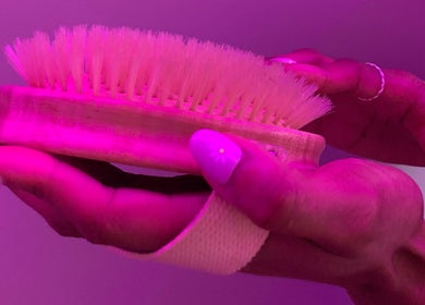 Hand holding a soft brush for relaxation at SIESTA7, Nottingham, England, GB.