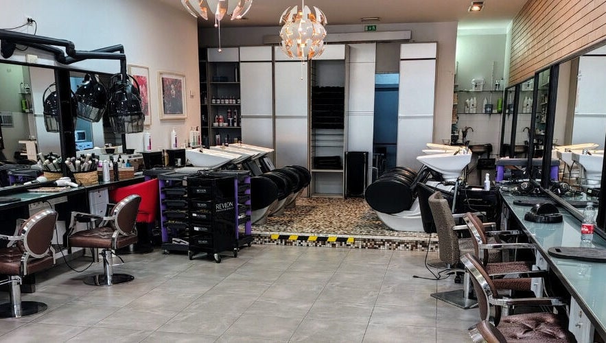Interior moderno do PAC CABELEIREIROS em Lisboa, Lisboa, PT, com cadeiras de salão e lavatórios elegantes.