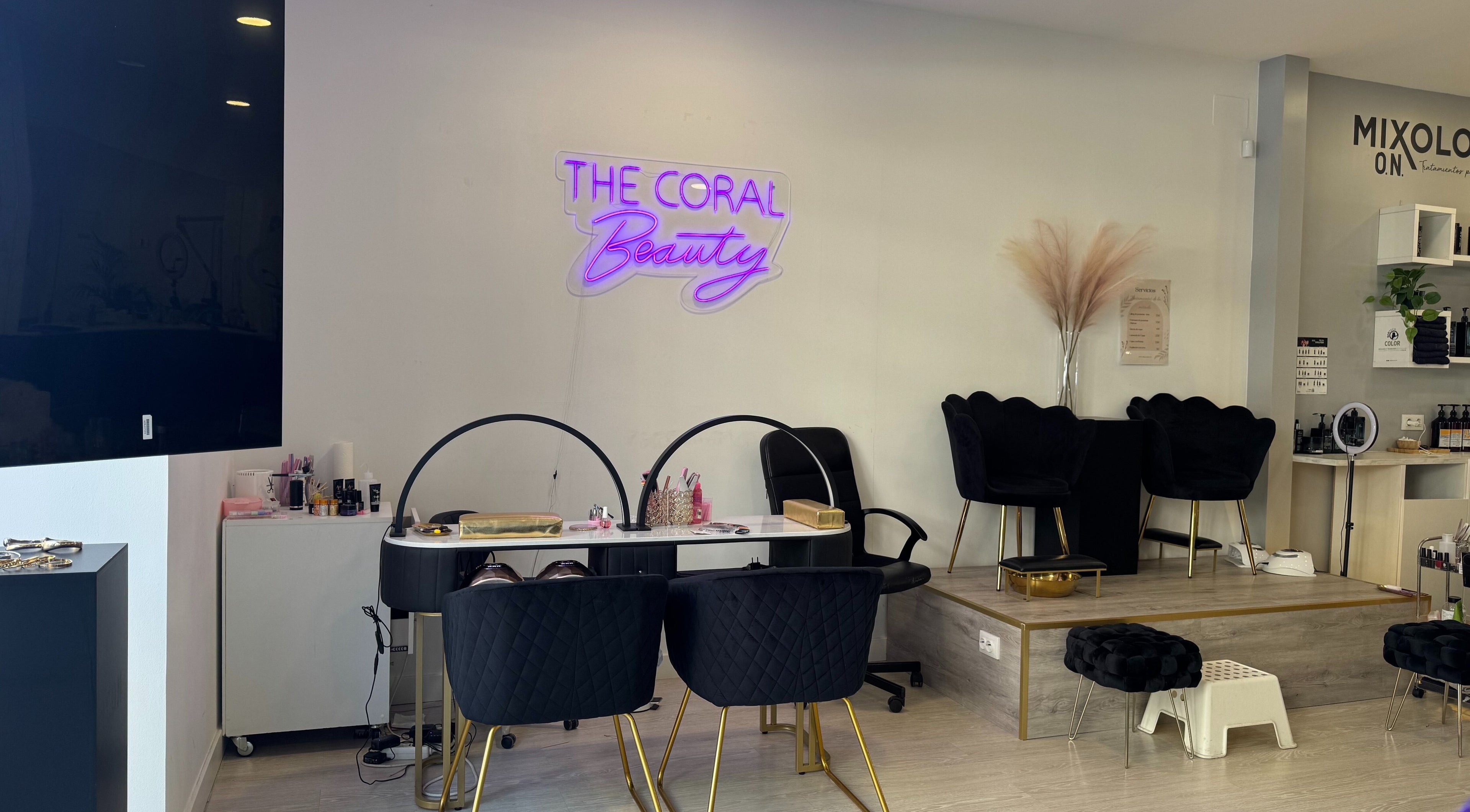 Interior elegante de The Coral Beauty en Madrid, Comunidad De Madrid, ES, con decoración moderna y sillas negras.