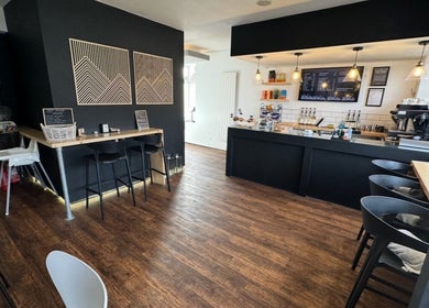 Relaxing café at PAB, Newcastle upon Tyne, England, GB with dark decor and Buddha statue.