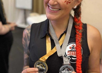 Femme souriante avec médailles à Kim Brunet Choisir Le Bonheur, Mirabel, Quebec, CA.