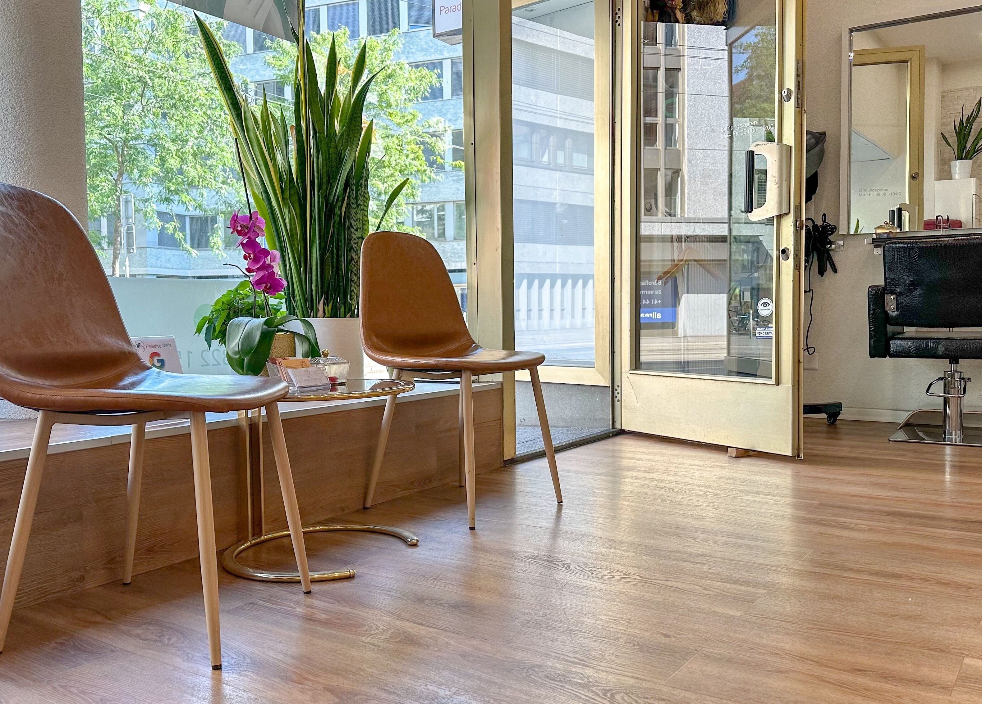 Inviting salon entrance at STUDIO GIULIA, Zürich, CH with elegant seating and vibrant plants.