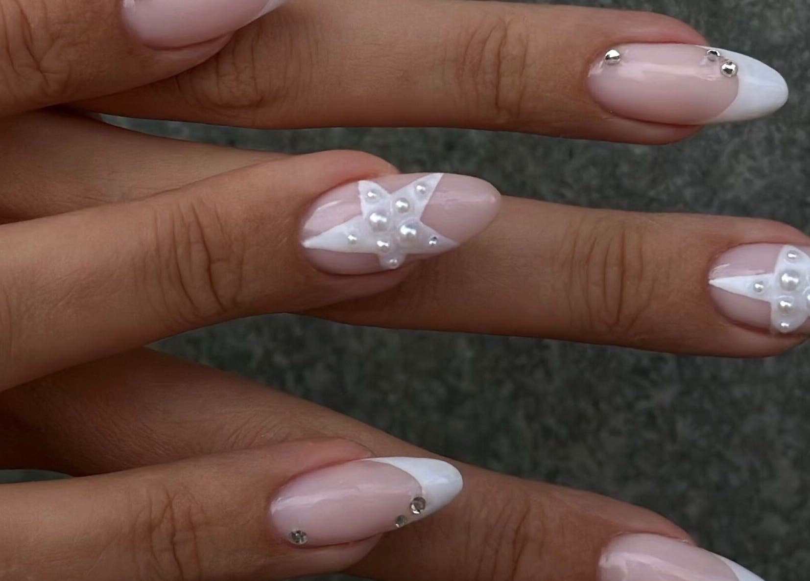 Elegant pearl nail design at STUDIO GIULIA, Zürich, CH showcasing intricate star patterns.