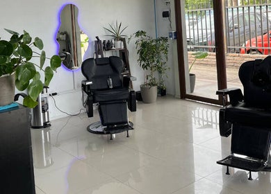 Interior moderno y acogedor de BLOOD STUDIO en Cachapoal, O'higgins, CL con sillones de peluquería.