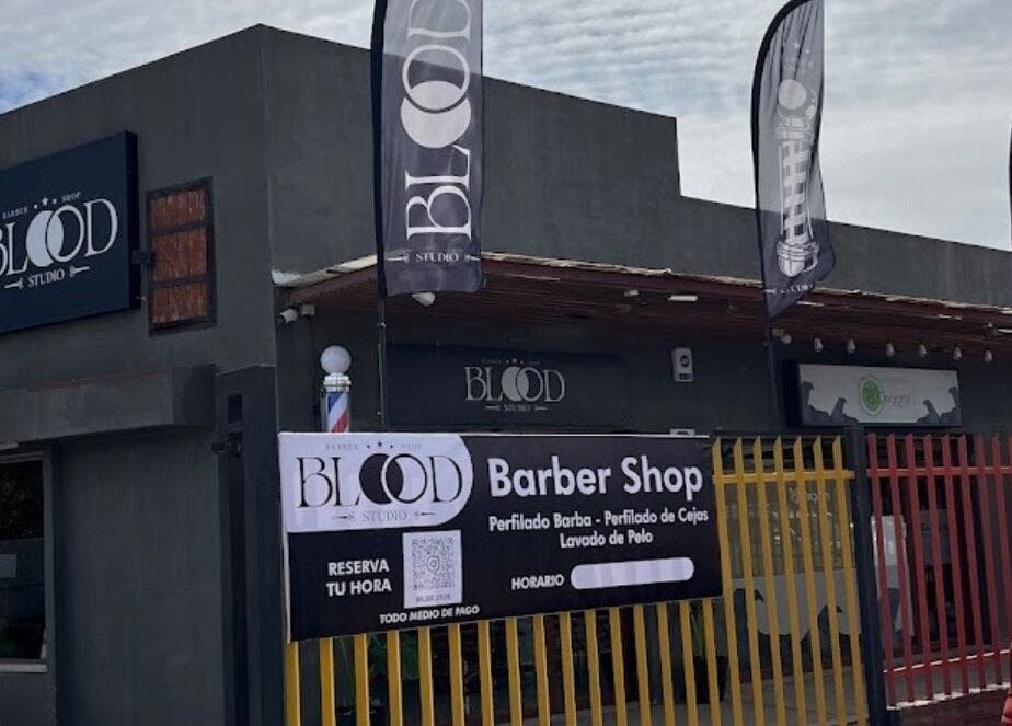 Fachada de Blood Studio en Cachapoal, O'higgins, CL, mostrando el letrero y banderas al exterior.