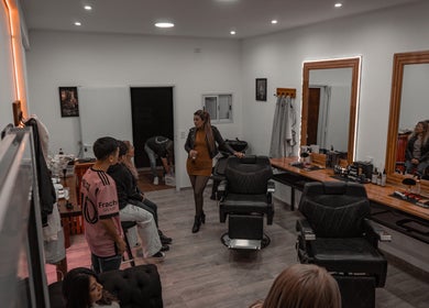 Interior animado de Estudio barber estilo en San Luis, San Luis, AR, con sillas y clientes conversando.