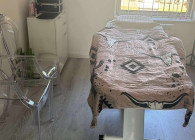 Calm treatment room at TJ Nails & Beauty in Ripley, England, GB featuring a comfy massage bed and modern decor.