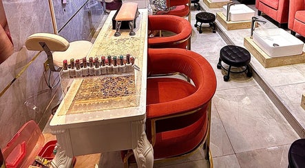 Luxurious nail care station at GIGI BEAUTY CENTER, Dubai, with plush red chairs and nail polish display.