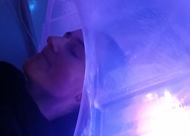 Calming blue light envelops a client during treatment at Solace Head Spa, Llandudno, Wales, GB.