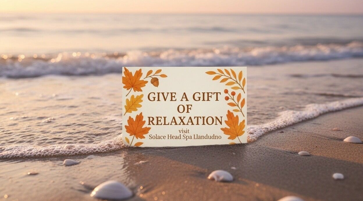Gift card at shoreline reading 'Give a Gift of Relaxation' for Solace Head Spa, Llandudno, Wales, GB.