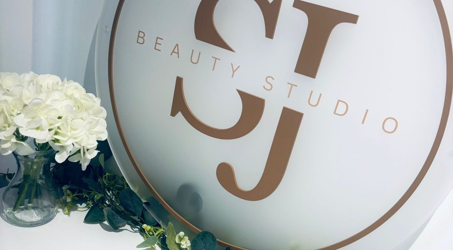 SJbeautystudio logo with white flowers in Stevenage, England, GB showcasing a tranquil ambiance.