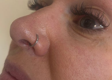 Close-up of nose with a hoop piercing at SJbeautystudio, Stevenage, England, GB.