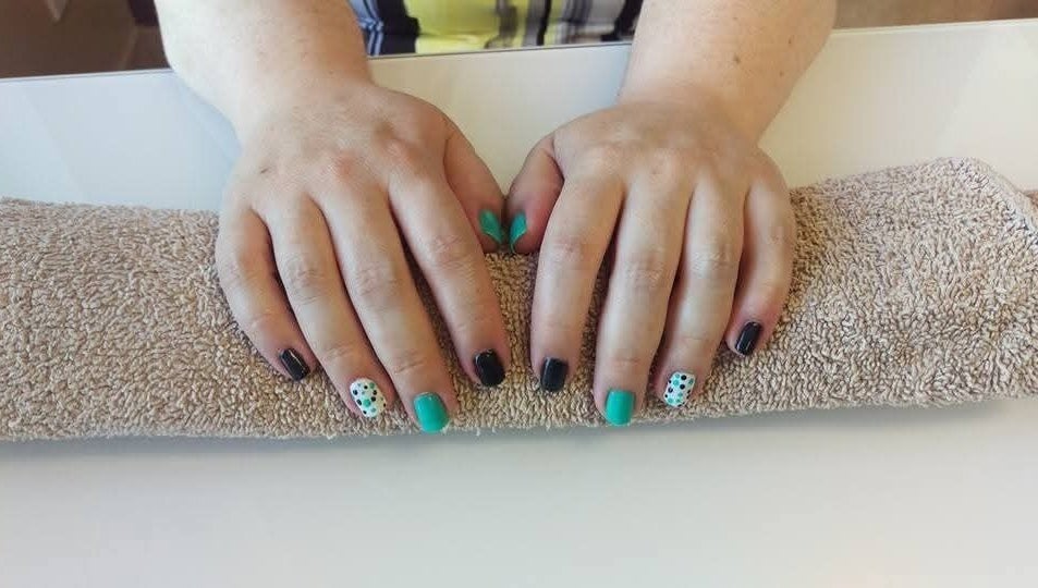 Colorful nail art manicure at Krystyn's Mobile Spa in Barrie, Ontario, CA, showcasing unique designs on two hands.