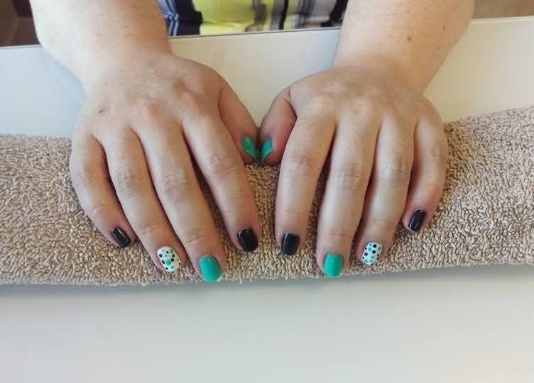 Colorful nail art manicure at Krystyn's Mobile Spa in Barrie, Ontario, CA, showcasing unique designs on two hands.