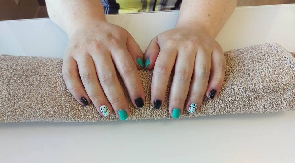 Colorful nail art manicure at Krystyn's Mobile Spa in Barrie, Ontario, CA, showcasing unique designs on two hands.
