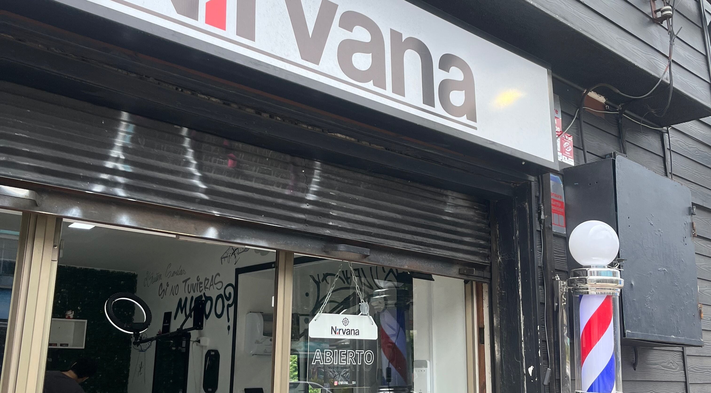 Fachada del salón bastii troncoso en Puerto Montt, Los Lagos, CL, con cartel de 'Abierto' y faro de barbería.