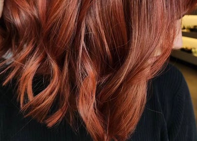 Coiffure élégante chez Joanie coiffe à Hawkesbury, Ontario, CA, mettant en valeur des cheveux cuivrés ondulés.