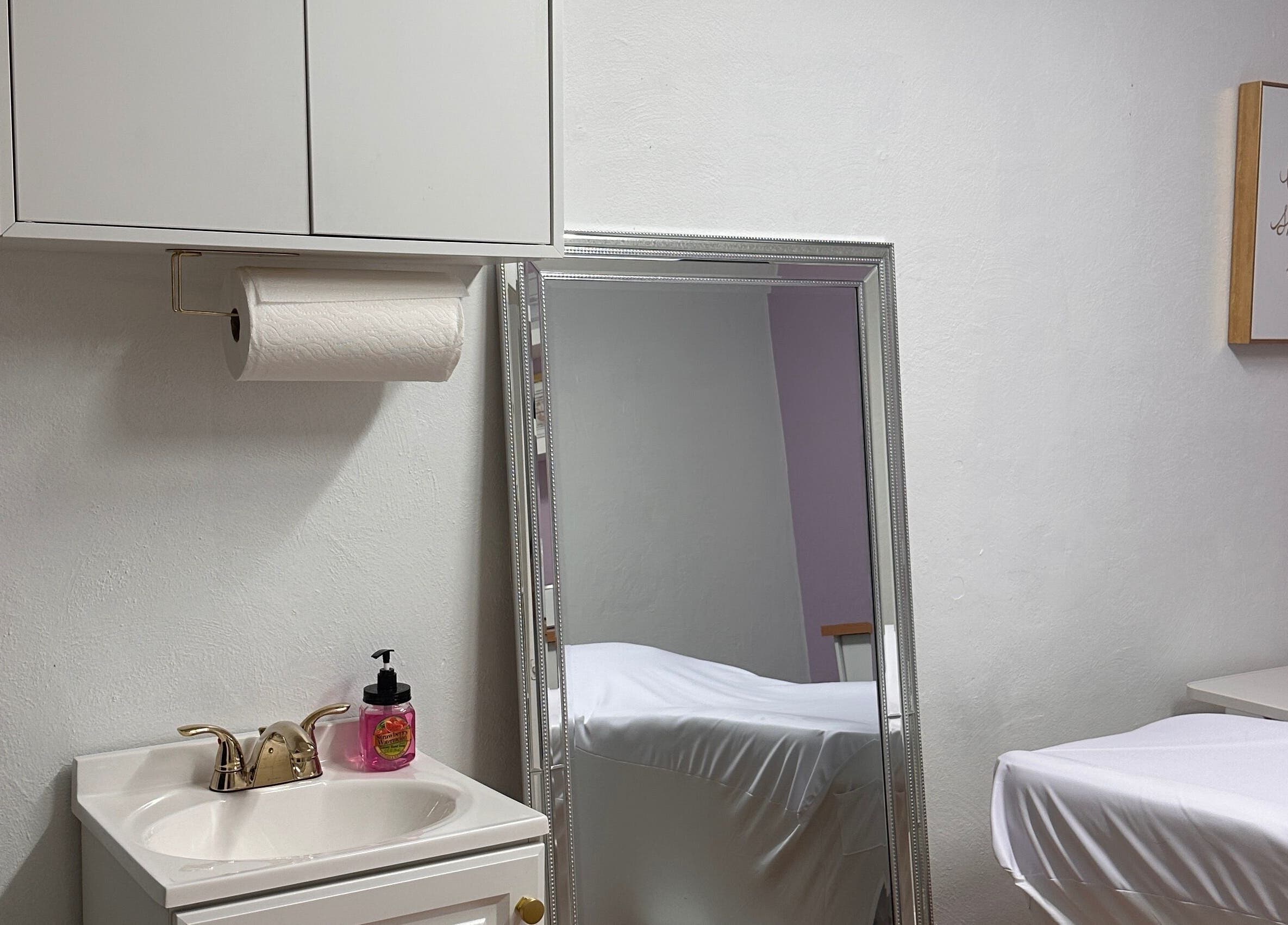 Relaxing treatment room at Waxing by Ana Spadeto in Pompano Beach, Florida, US with modern decor and mirror.