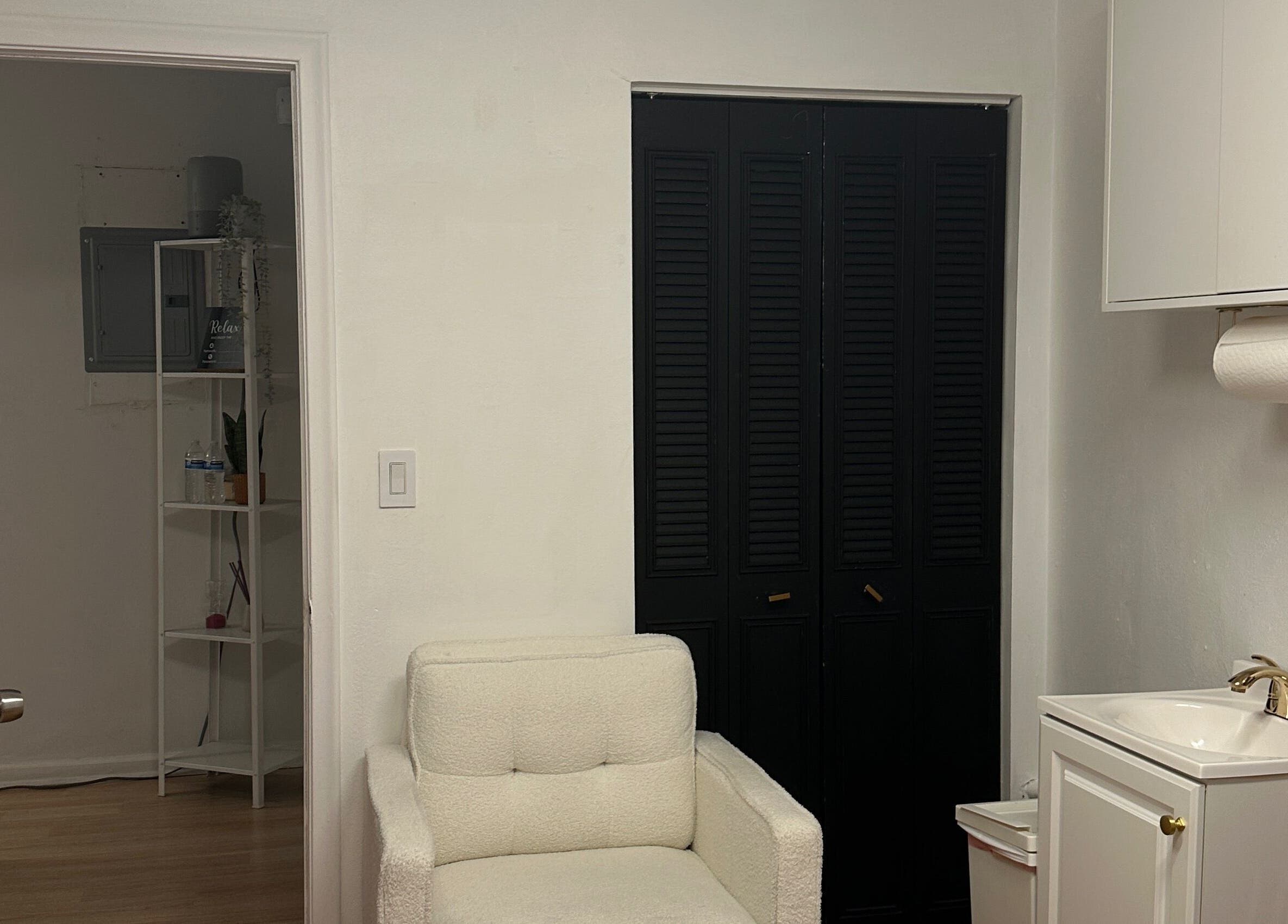 Cozy interior at Waxing by Ana Spadeto, Pompano Beach, Florida, US with plush chair and sink.