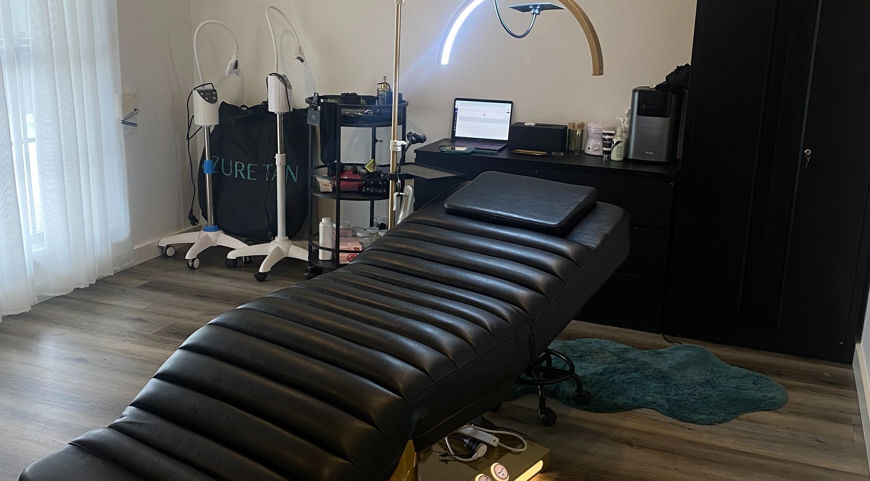 Tranquil spa room at DĀNA X BEAUTY, Liverpool, New South Wales, AU with modern equipment and plush black bed.